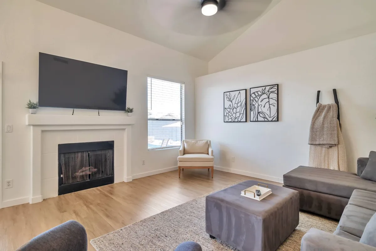 This interior shot highlights a cozy family room featuring a sectional sofa, decorative fireplace, and a TV mounted on the wall. The space is styled for comfort and entertainment, perfect for movie nights or relaxed evenings with family and friends.